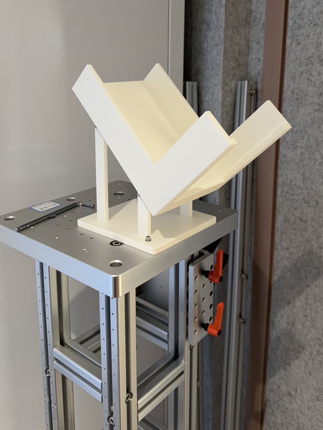 White 3D-printed V-shaped support mounted on an aluminum test stand